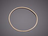 a gold rope bracelet on a gray background