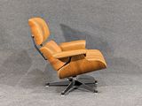 an eames chair with a wooden base and leather upholstered seat
