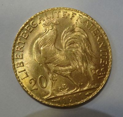 a close up of a gold coin with a rooster on it