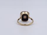 a close up of a gold ring with a black stone on it
