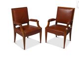 two brown leather chairs with wooden arms and arms