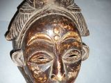 an image of a wooden mask hanging on a wall