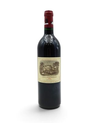 a bottle of red wine sitting on top of a white table