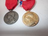 two medals sitting next to each other on a white surface