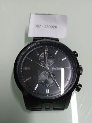 a black watch with a black face on a glass table