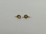 une paire de boucles d'oreilles en or sur fond blanc