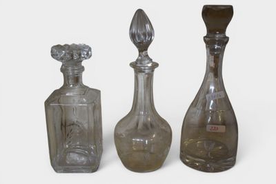 three glass bottles are lined up next to each other on a white surface