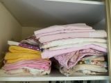 une étagère sur laquelle sont posés de nombreux vêtements pliés