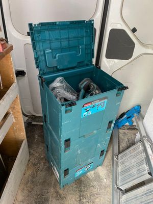 une boîte bleue contenant deux bouteilles, posée à côté d'une échelle