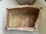 a stone bowl that is sitting on the floor
