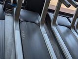 two tread machines are lined up in a row in a gym