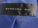 a close up of a blue jacket with a black label on it
