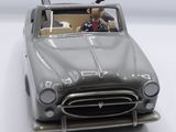a toy car with a man sitting in the driver ' s seat