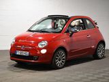 La petite voiture rouge est garée dans le garage, sur le sol à damier.