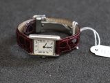 une montre posée sur une table, à laquelle est attachée une étiquette