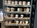 de nombreuses tasses et mugs sur les étagères du magasin