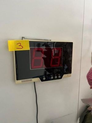 une horloge accrochée au mur à côté d'une peluche