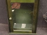 a small green cabinet with a mirror on the floor