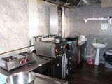 a kitchen with a sink, stove, stove top, and a sink