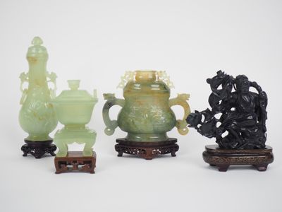 trois vases en jade et un petit vase posé sur un socle