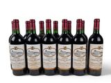 six bottles of wine are lined up in a row on a white surface