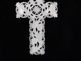 a white cross with a gold chain on a black background