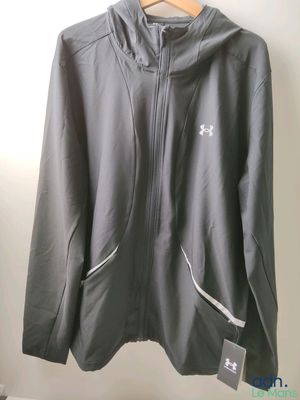 une veste grise suspendue à un cintre dans une pièce