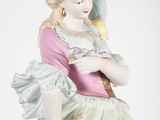 a figurine of a woman with a bird on her shoulder
