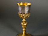 an antique silver and gold goblet sitting on top of a table