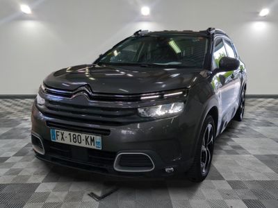 La Citroën grise est garée sur un sol à damier dans un garage.