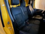 a yellow van with black seats in the back of it