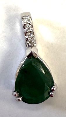 un gros plan d'un pendentif composé d'une pierre verte et d'un diamant, sur fond blanc