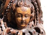 a wooden carving of a woman with a bird on her head
