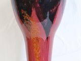 a vase that has a red and black design on it