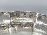 a silver plate with a design on it