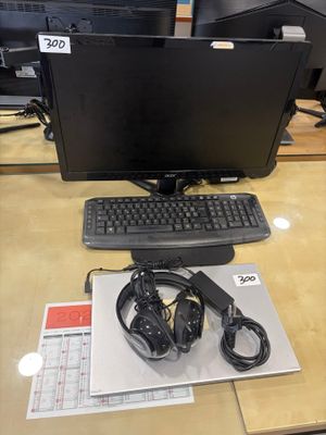 un bureau sur lequel se trouvent un écran, un clavier, un casque et une souris