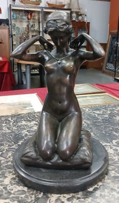 une statue de femme assise sur une table