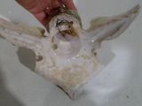 une main tenant une petite figurine représentant un ange