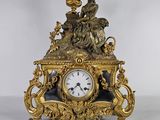 une horloge en or surmontée d'un oiseau