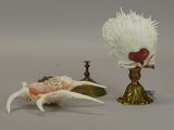 a shell and a flower on a table next to a candle