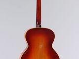 an acoustic guitar hanging from the ceiling in a room