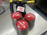 quatre canettes de soda posées sur une table dans une cuisine