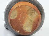 a close up of a cup of soup on a white surface