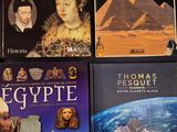 plusieurs livres posés sur une table, avec une image de pyramide en arrière-plan
