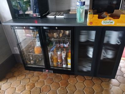 un petit réfrigérateur contenant des boissons, dans une pièce