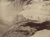 an old black and white photo of a waterfall in the snow