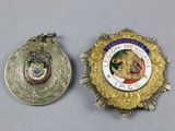 two medals are shown next to each other on a table