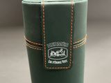 a green cup that has a brown stitching on it