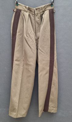 an old pair of pants hanging on a hanger on a wall