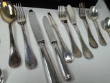 a lot of silver spoons and forks on the table